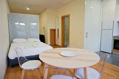 a room with a bed and a table and chairs at Tomás Flat in Porto