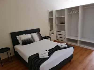 a bedroom with a bed with white sheets and pillows at Tomás Flat in Porto