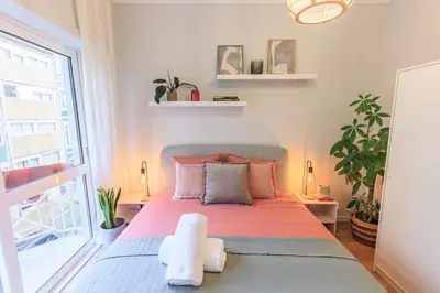 a bedroom with a bed and a large window at Enjoy Bonfim Central 2BR Renovated Apartment by LovelyStay in Porto