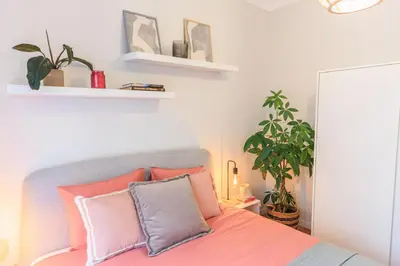 a bedroom with a bed with pink and grey pillows at Enjoy Bonfim Central 2BR Renovated Apartment by LovelyStay in Porto