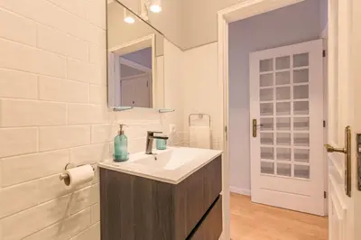 a white bathroom with a sink and a mirror at Enjoy Bonfim Central 2BR Renovated Apartment by LovelyStay in Porto