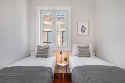 two beds in a white room with a window at Whome Formosa #3 - Central 2-Bed in Prime Location Perfect to Explore Porto in Porto