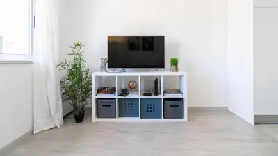 a white entertainment center with a tv on top at Delightful Bombarda Apartment by Unique Hosts in Porto