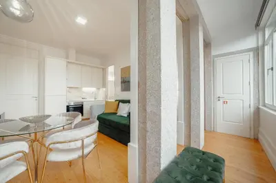 a kitchen and a living room with a table and chairs at Downtown Premium Apartment by Vacationy in Porto