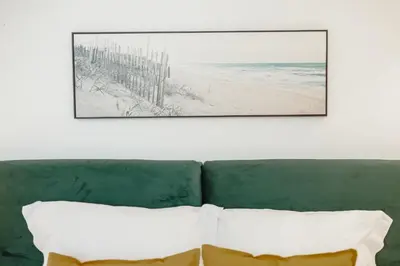 a picture of the beach and a green couch with two pillows at Downtown Premium Apartment by Vacationy in Porto