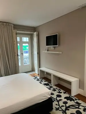 a bedroom with a bed and a tv on the wall at Oporto Chic & Cozy Cardosas in Porto