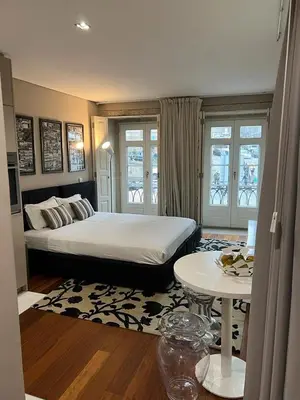 a bedroom with a large bed and a table at Oporto Chic & Cozy Cardosas in Porto