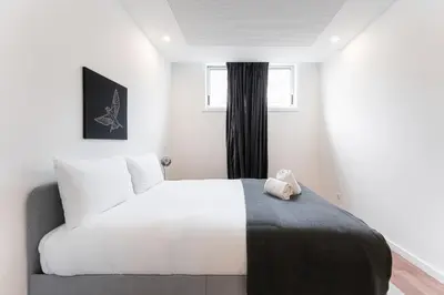 a bedroom with a white bed and a window at GuestReady - Uptown suites in Porto
