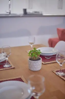 a table with plates and glasses and a potted plant on it at Maison214 in Vila Nova de Gaia
