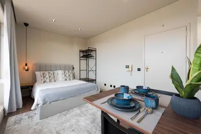 a bedroom with a bed and a large window at DOISPONTOZERO Júlio Dinis in Porto