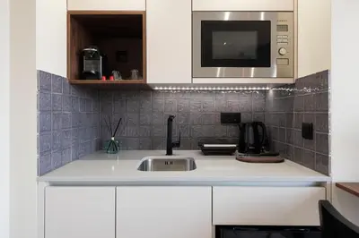 a kitchen with a sink and a microwave at DOISPONTOZERO Júlio Dinis in Porto
