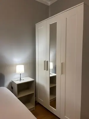a bedroom with a white cabinet and a lamp at Lindo apartamento em Gaia ao lado Bodegas in Vila Nova de Gaia