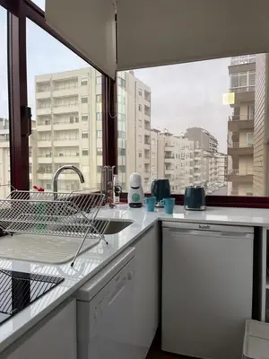 a kitchen with a sink and a view of a city at Lindo apartamento em Gaia ao lado Bodegas in Vila Nova de Gaia