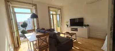a living room with a couch and a tv at Merc Porto Estudio 245 in Porto