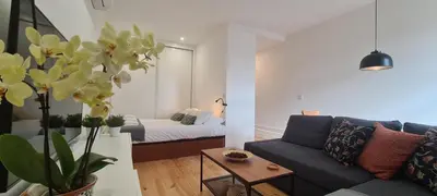 a living room with a couch and a bed at Merc Porto Estudio 245 in Porto