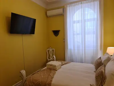 a white bed with a white headboard in a bedroom at Casinhas no Carolina - Hostel in Porto