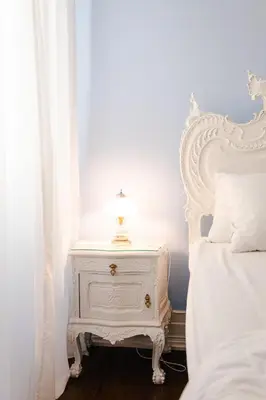 a white headboard of a bed with white pillows at Casinhas no Carolina - Hostel in Porto
