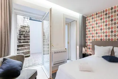 a bedroom with a bed and a chair and a window at Door 65 - Historical Center Apartments in Porto