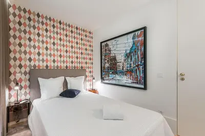 a bedroom with a white bed and a painting on the wall at Door 65 - Historical Center Apartments in Porto