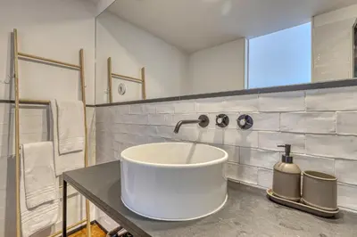 a bathroom with a white sink and a mirror at Formosa Patio with Free Parking in Porto