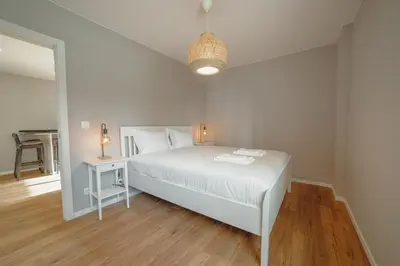 a white bedroom with a white bed and a table at Crystal Palace Garden Stylish Apartment by Vacationy in Porto