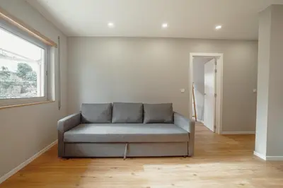 a gray couch in a room with a window at Crystal Palace Garden Stylish Apartment by Vacationy in Porto