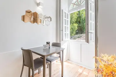 a dining room with a table and chairs and a window at GuestReady - San Sebastian Studios in Porto