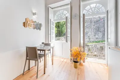 a dining room with a table and two windows at GuestReady - San Sebastian Studios in Porto
