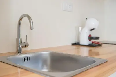 a stainless steel kitchen sink on a wooden counter at GuestReady - San Sebastian Studios in Porto