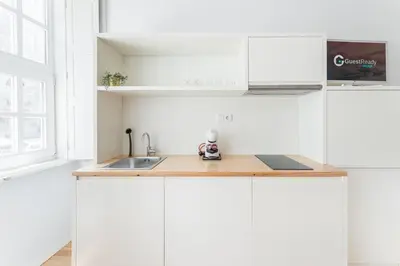 a kitchen with white cabinets and a sink at GuestReady - San Sebastian Studios in Porto