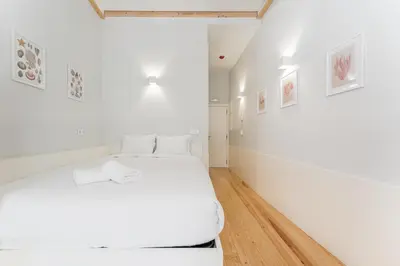 a bedroom with white walls and a white bed at GuestReady - San Sebastian Studios in Porto