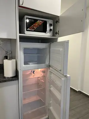 an open refrigerator with a microwave on top of it at Almada Downtown 102 in Porto