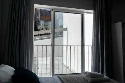 a bedroom with a window with a view of a balcony at Almada Downtown 103 in Porto
