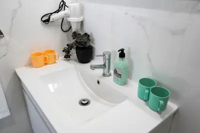 a bathroom sink with two cups and a bottle of soap at Almada Downtown 103 in Porto