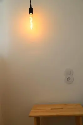 a light hanging from a wall next to a wooden table at Casa do Pilar - D. Luís I in Vila Nova de Gaia