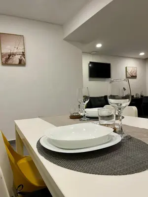 a table with a plate and wine glasses on it at Almada Downtown 104 in Porto