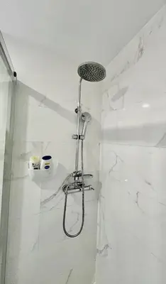 a shower in a bathroom with white marble walls at Almada Downtown 201 in Porto