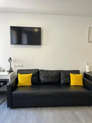 a black couch with yellow pillows in a living room at Almada Downtown 201 in Porto