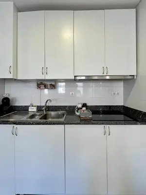 a kitchen with white cabinets and a sink at Almada Downtown 201 in Porto