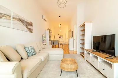 a living room with a white couch and a television at Republica I by Innkeeper in Porto