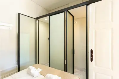 a bathroom with a mirror and a bed with towels at Soprano Loft Porto Center - by Guest SPA in Porto