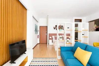 a living room with a blue couch and a television at Valentino Loft Porto Center - by Guest SPA in Porto