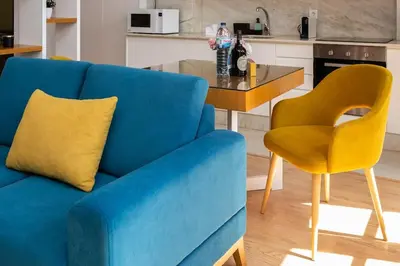 a blue couch and a yellow chair in a kitchen at Valentino Loft Porto Center - by Guest SPA in Porto