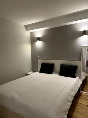 a bedroom with a large white bed with two pillows at Almada One in Porto