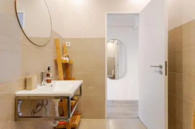 a bathroom with a sink and a mirror and a shower at Serpa Downtown Gaia in Vila Nova de Gaia