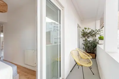 a room with a chair next to a window at Serpa Downtown Gaia in Vila Nova de Gaia