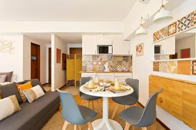 a living room with a couch and a table and chairs at Aposentus - Downtown Bright Apartment in Porto