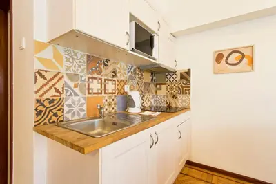 a kitchen with a sink and tiles on the wall at Aposentus - Downtown Bright Apartment in Porto