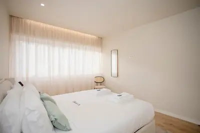 a large white bed in a room with a window at Liiiving in Porto - Uptown Pearl Apartment in Porto