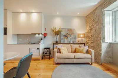 a living room with a couch and a kitchen at Oporto Pool Apartment by Vacationy in Porto